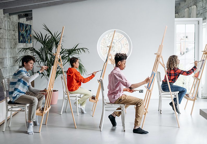 A group of people sitting in chairs with easels.