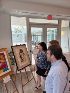 People viewing framed art in a gallery.