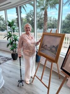Woman standing by painting in bright room.