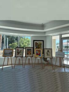 Art exhibition with paintings on easels indoors.
