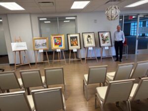 Art exhibition setup with paintings on easels.