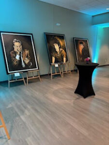 Art gallery with three framed portraits displayed.