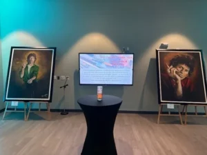 Art exhibit with two framed portraits displayed.