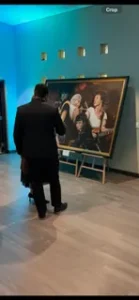 People viewing a large framed painting.