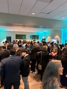 Crowded event with people socializing indoors.